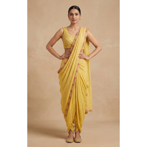 Woman wearing a yellow saree with a plain background