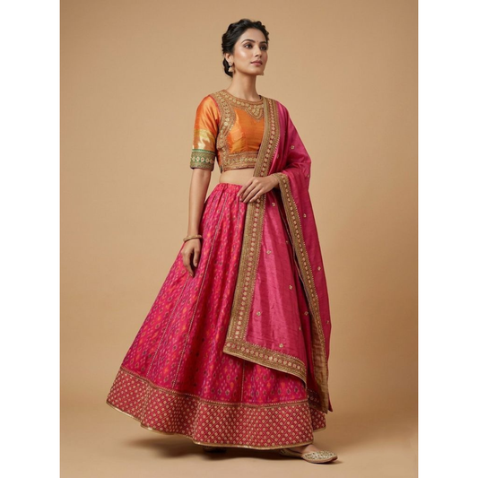 Woman wearing a traditional pink and orange saree with gold border on a beige background