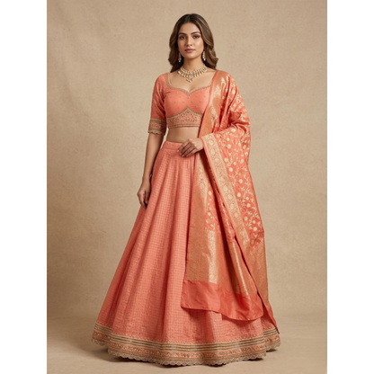 Woman wearing a traditional peach-colored outfit with intricate designs on a beige background