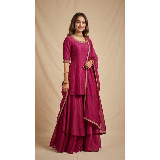 Woman wearing a magenta traditional outfit with gold accents on a beige background