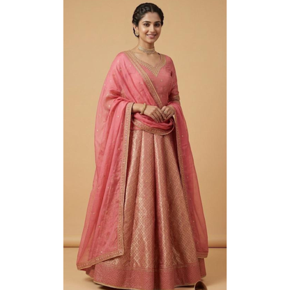 Woman wearing a pink saree with gold patterns on a beige background