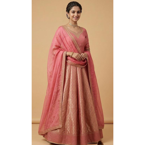 Woman wearing a pink saree with gold patterns on a beige background