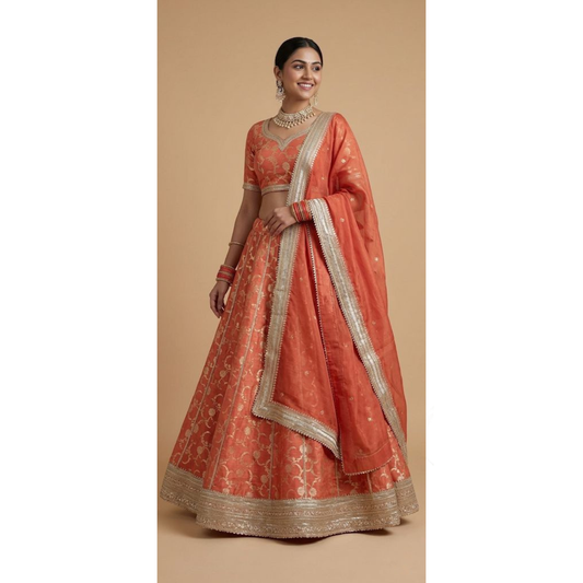 Woman wearing a traditional orange and gold embroidered outfit on a beige background