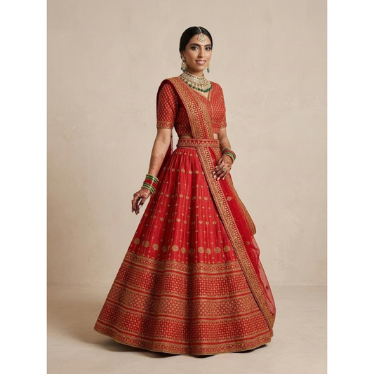 Woman wearing a traditional red and gold outfit with intricate patterns on a beige background
