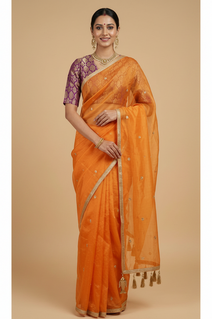 Woman wearing an orange saree with a beige background