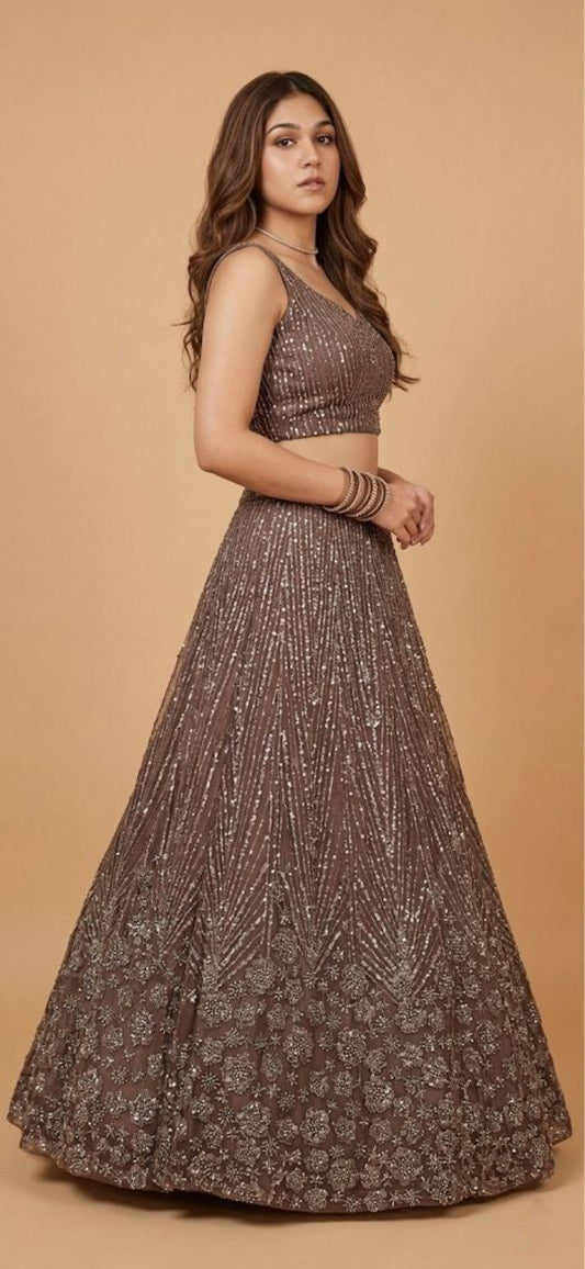 Woman wearing a traditional outfit with a long skirt and top on a beige background